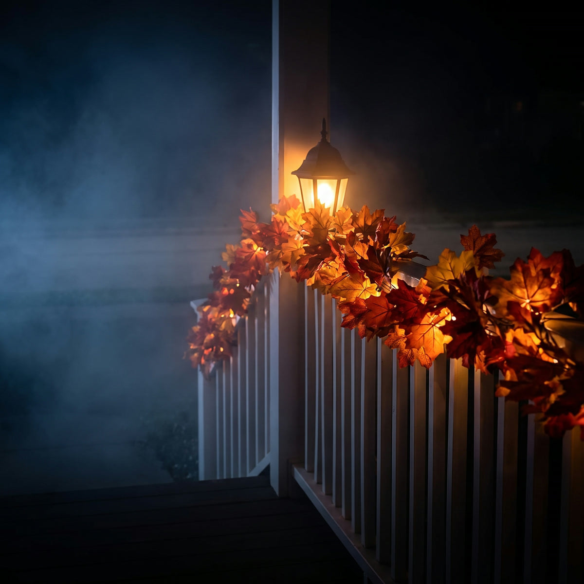 A maple leaf garland along a porch railing under a lantern